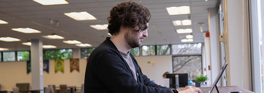 An SPU student works on their laptop in the Lower Weter Commuter Lounge